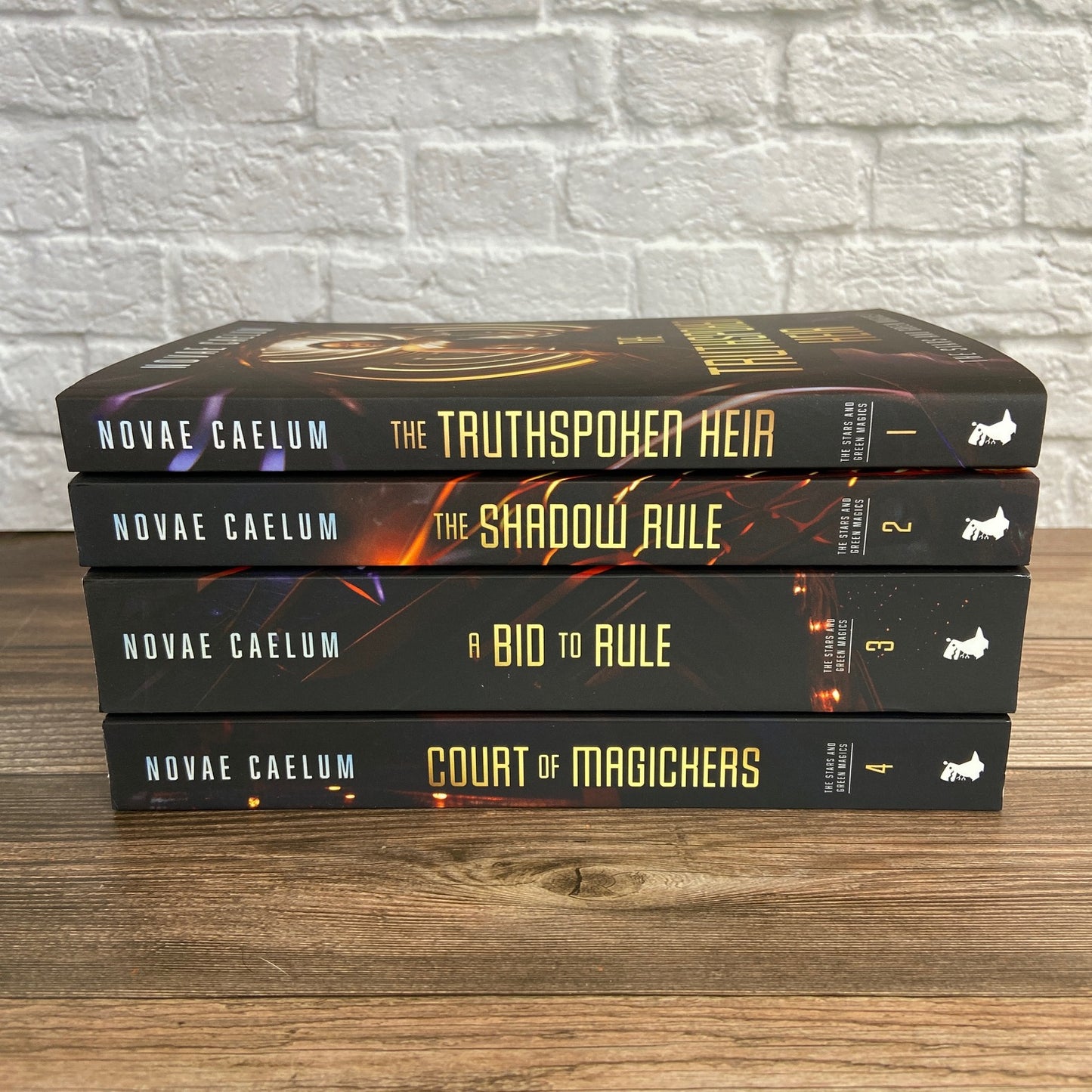 Stack of 4 paperbacks (Books 1-4) from "The Stars and Green Magics" series by Novae Caelum with spines facing outward.