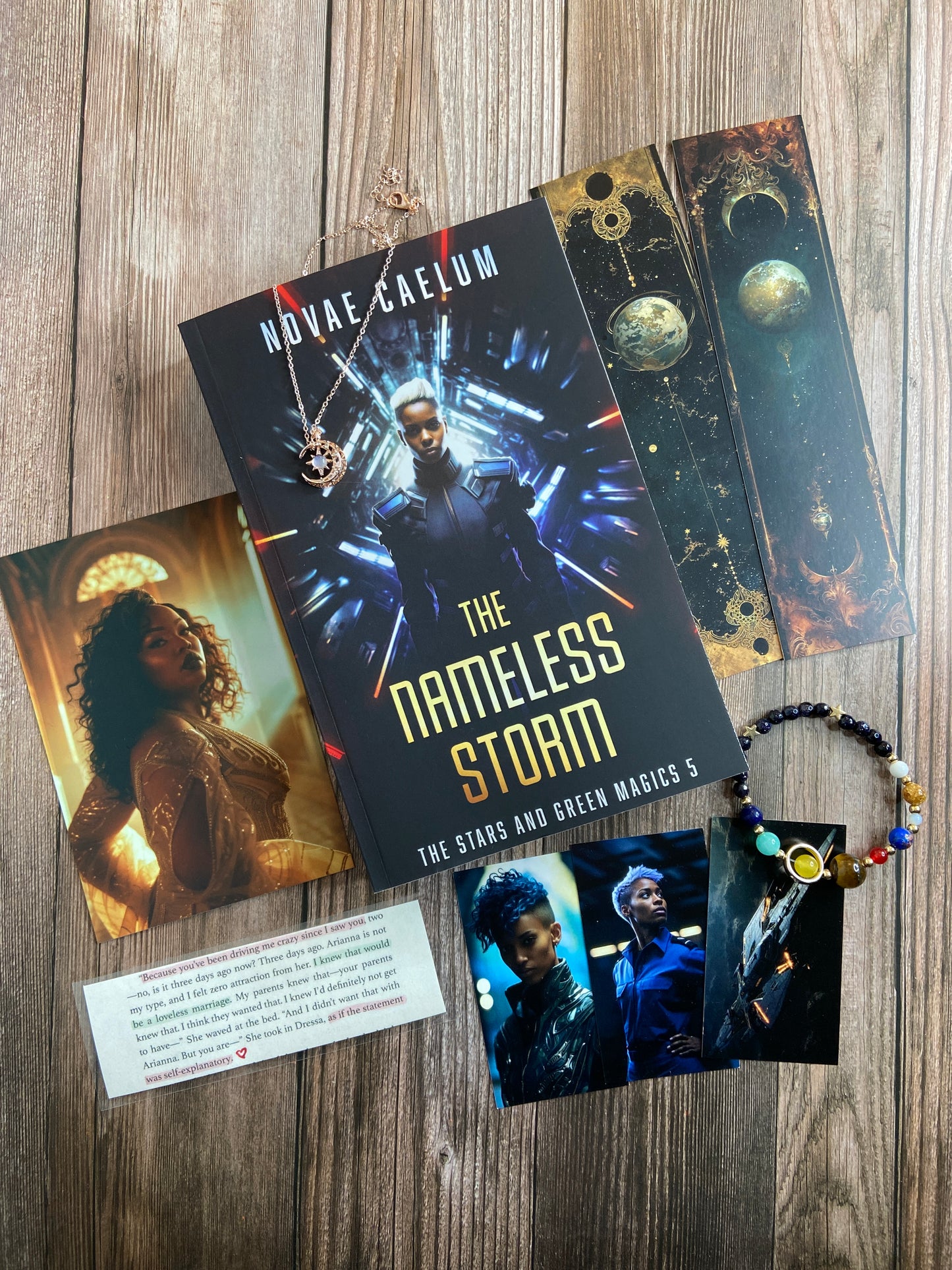 A collection of series-related swag arranged around the book. including a book titled "The Nameless Storm: The Stars and Green Magics - Book 5" by Novae Caelum; swag includes: bookmarks with celestial designs, a bracelet with colorful beads, and a card with text. This bundle is a Patreon Exclusive (Not for Sale).