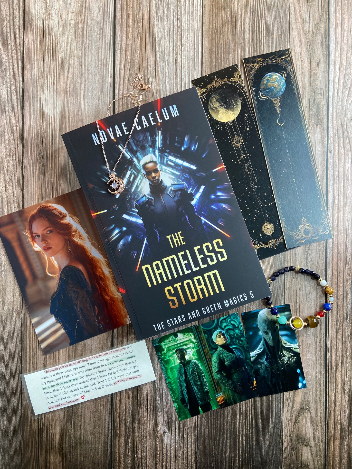 A collection of series-related swag arranged around the book. including a book titled "The Nameless Storm: The Stars and Green Magics - Book 5" by Novae Caelum; swag includes: bookmarks with celestial designs, a bracelet with colorful beads, and a card with text. This bundle is a Patreon Exclusive (Not for Sale).