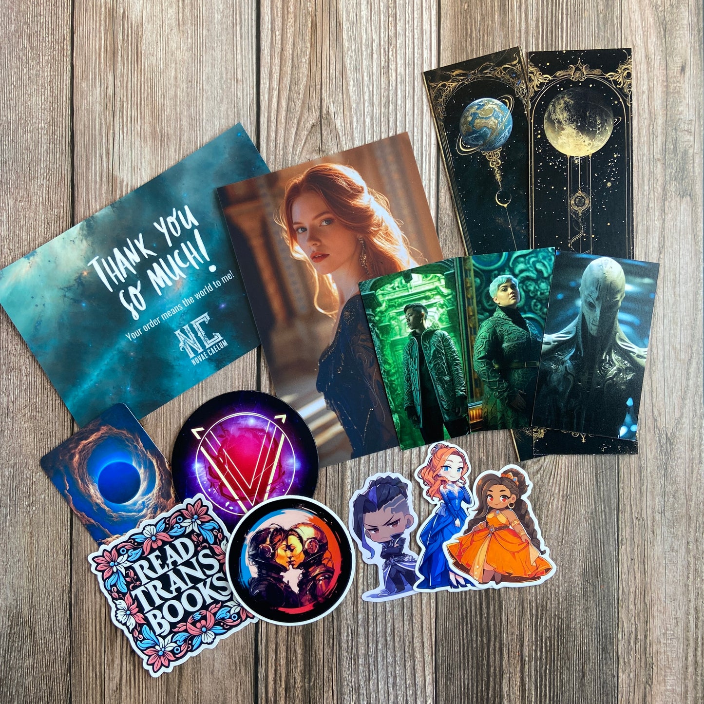 A collection of Novae Caelum's SIGNED Paperback Deluxe Swag Bundle: The Stars and Green Magics (Books 1-5), including bookmarks, stickers, and art prints, arranged on a wooden surface.