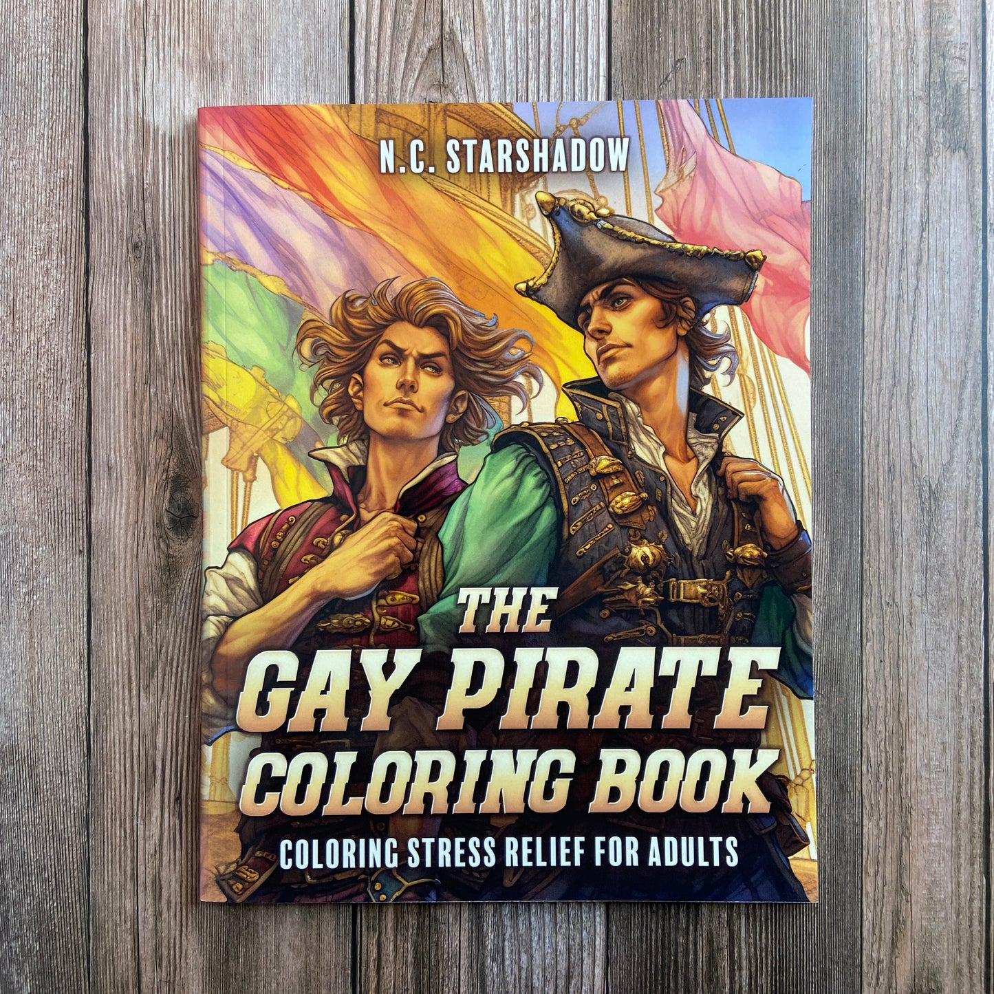 A coloring book titled "The Gay Pirate Coloring Book: Coloring Stress Relief for Adults" by N.C. Starshadow, featuring two gay pirates standing in front of Gay Pride flags on the cover. 