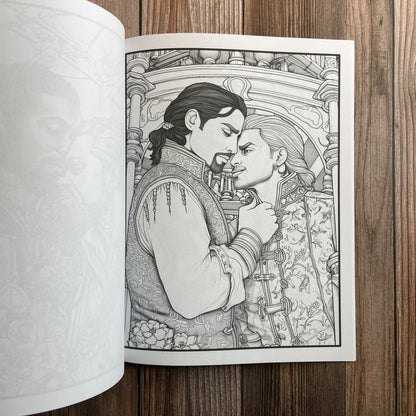 A coloring book (titled "The Gay Pirate Coloring Book: Coloring Stress Relief for Adults" by N.C. Starshadow) opened to display a black-line image of two gay pirates embracing.