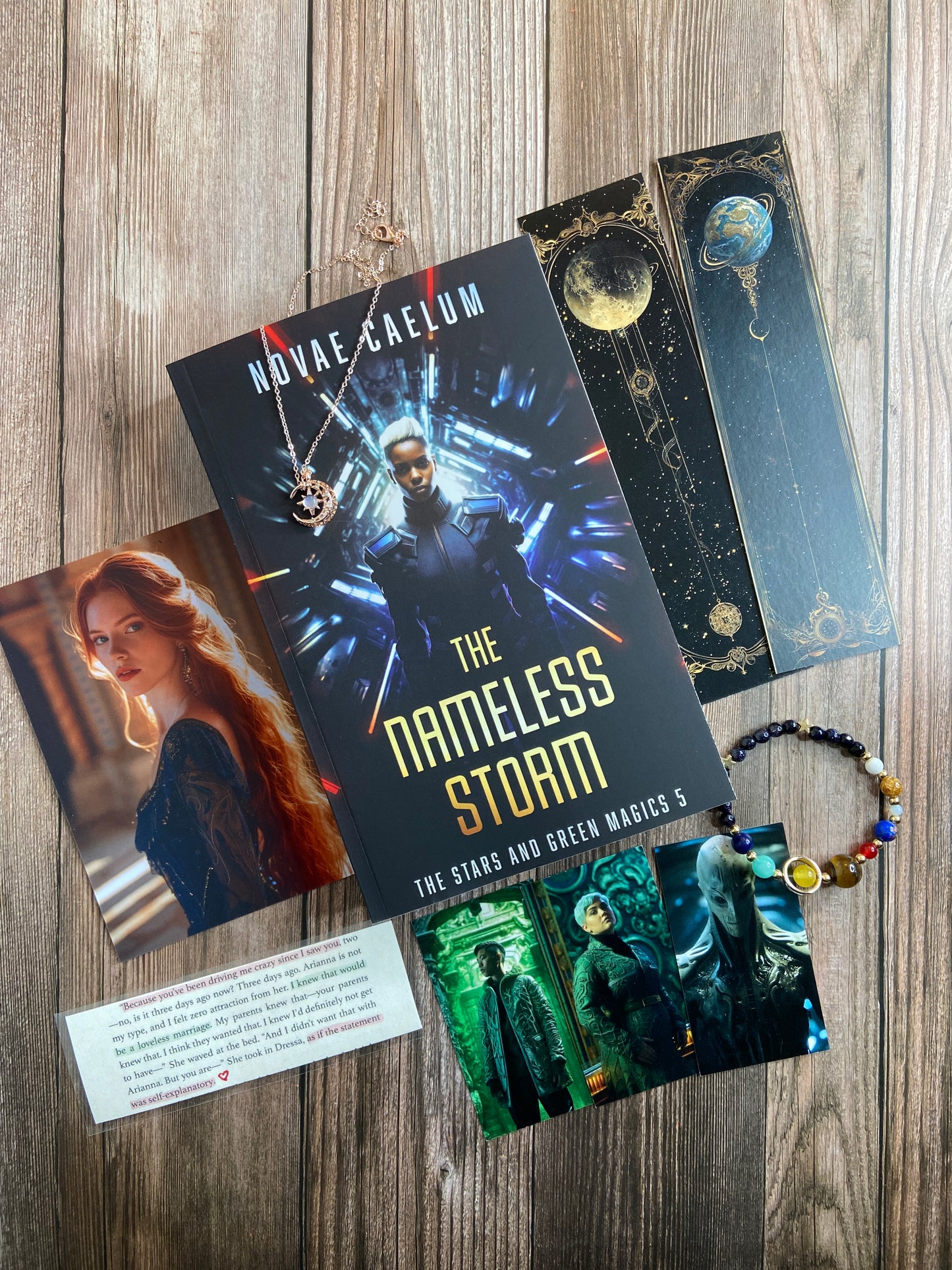 A collection of themed items including a book titled "The Nameless Storm Patreon Exclusive (Not for Sale)," bookmarks, a necklace, and a beaded bracelet arranged on a wooden surface, all within origami wrapped packaging by Novae Caelum.